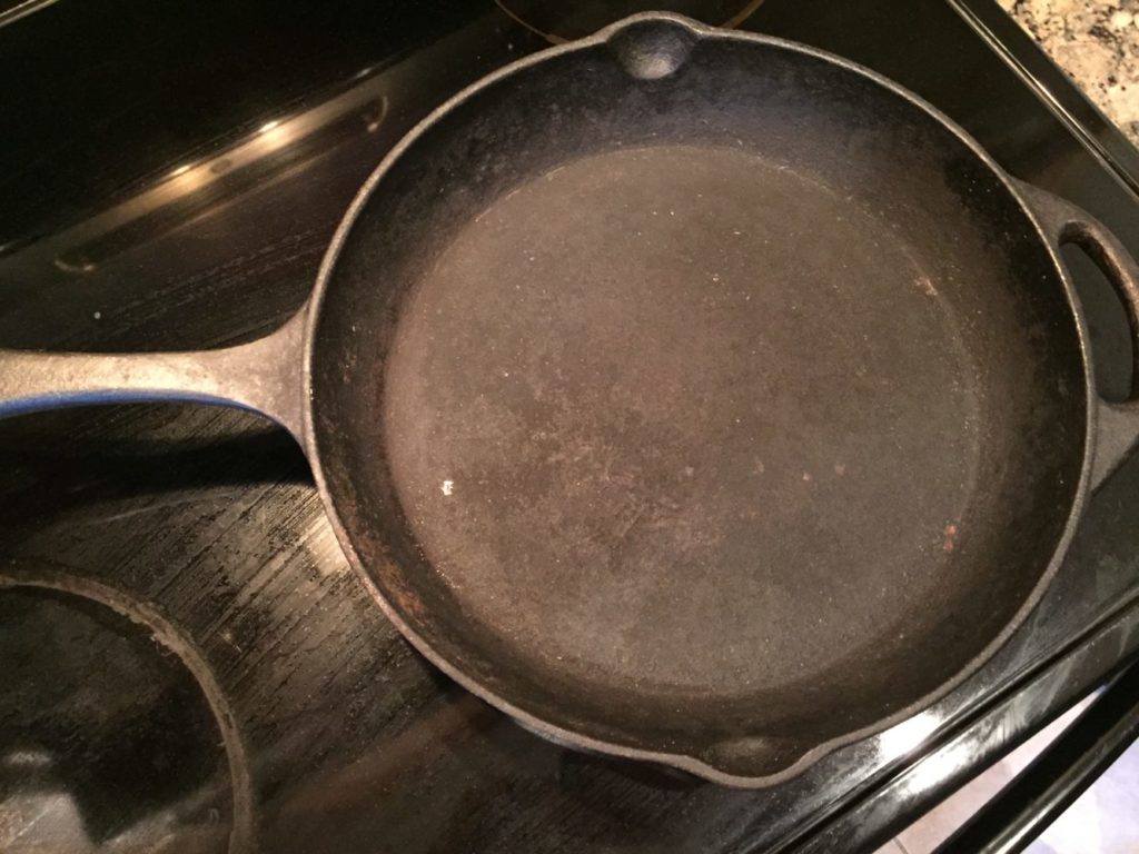 Overhead view of a cast iron skillet on a black cooktop
