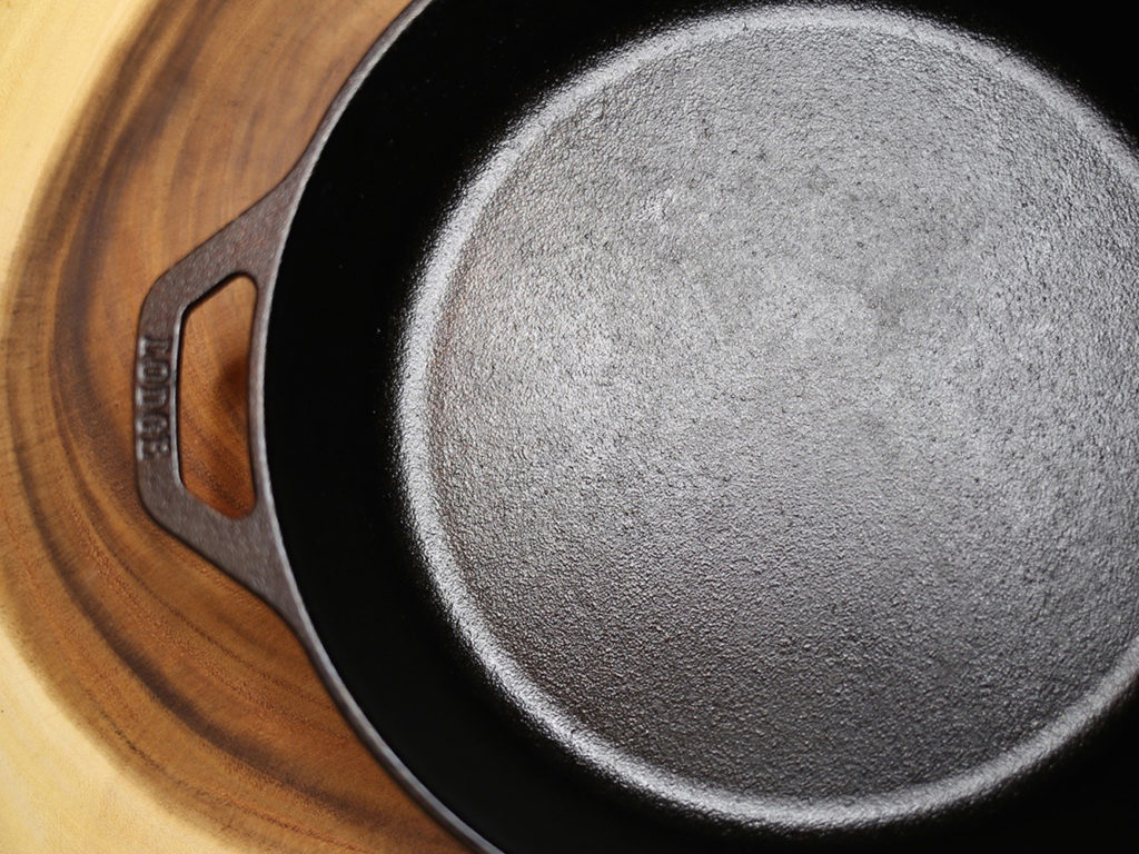 An overhead view of a cast iron skillet on a wood cutting board