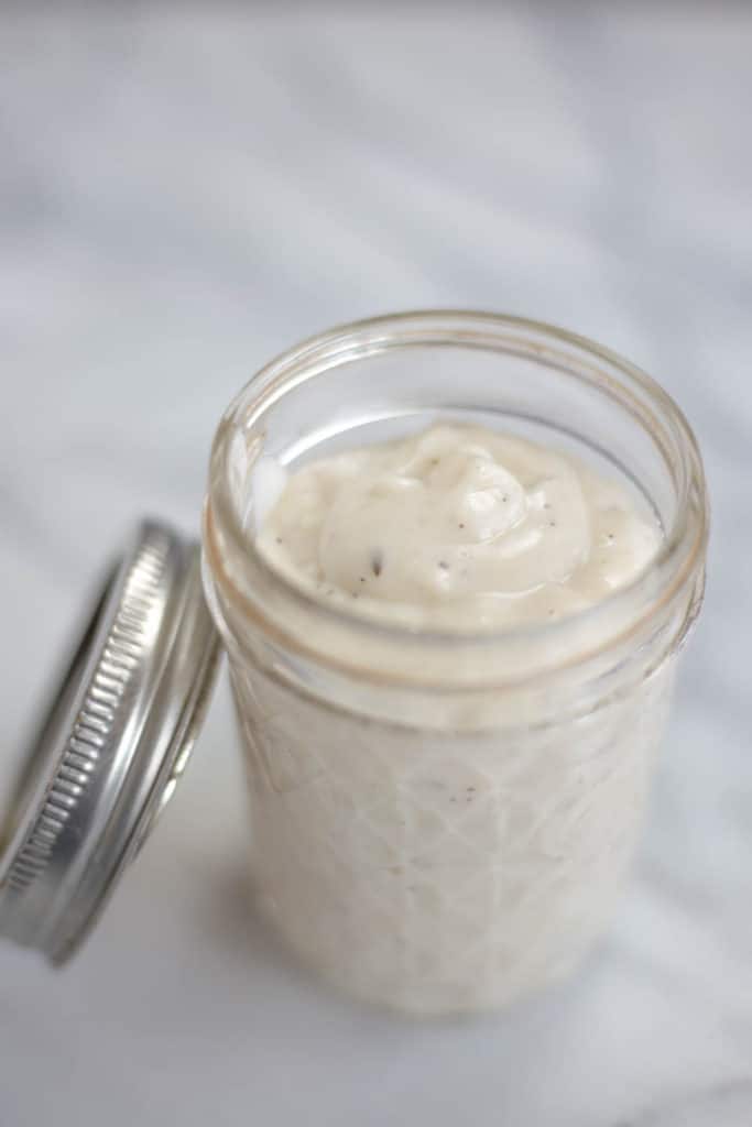 A mason jar filled with homemade condensed cream of chicken soup with the lid to the side