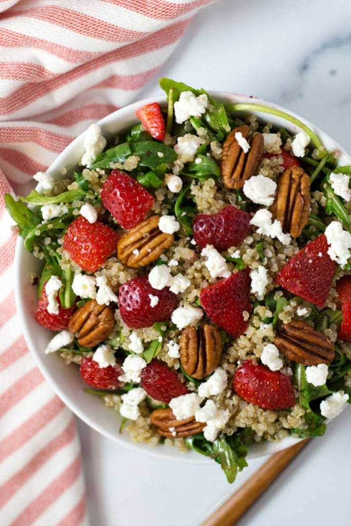 Overhead view of a salad with strawberries, goat cheese, and pecans