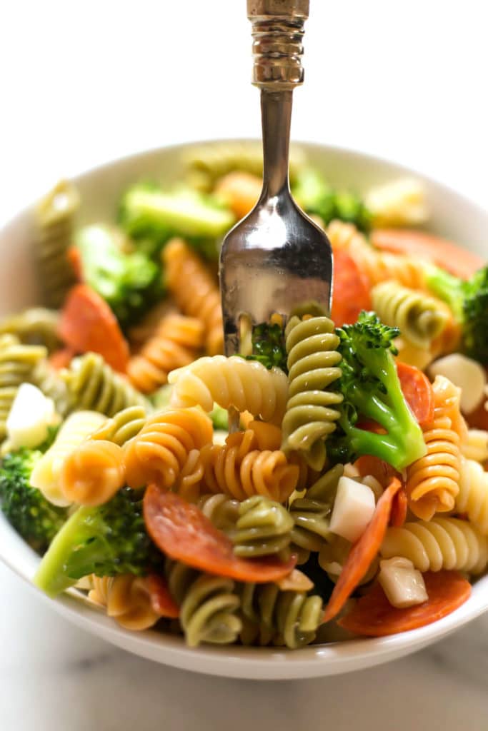 White bowl of pasta salad with a fork
