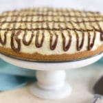 A white cake stand topped with a cheesecake