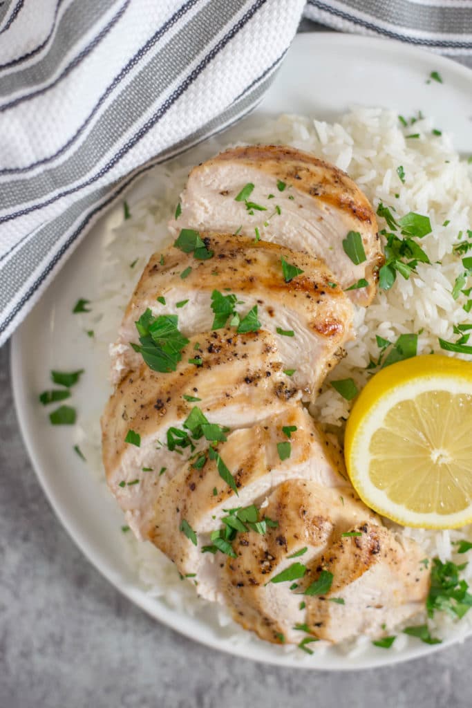 Plate of chicken and rice with lemon and fresh herbs