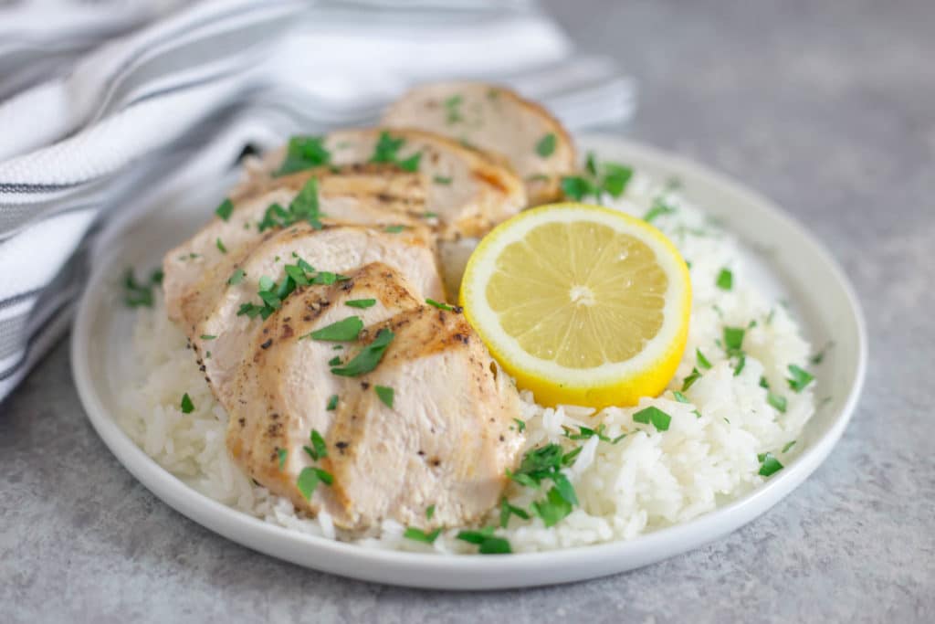 plate of chicken and rice with lemon and herbs