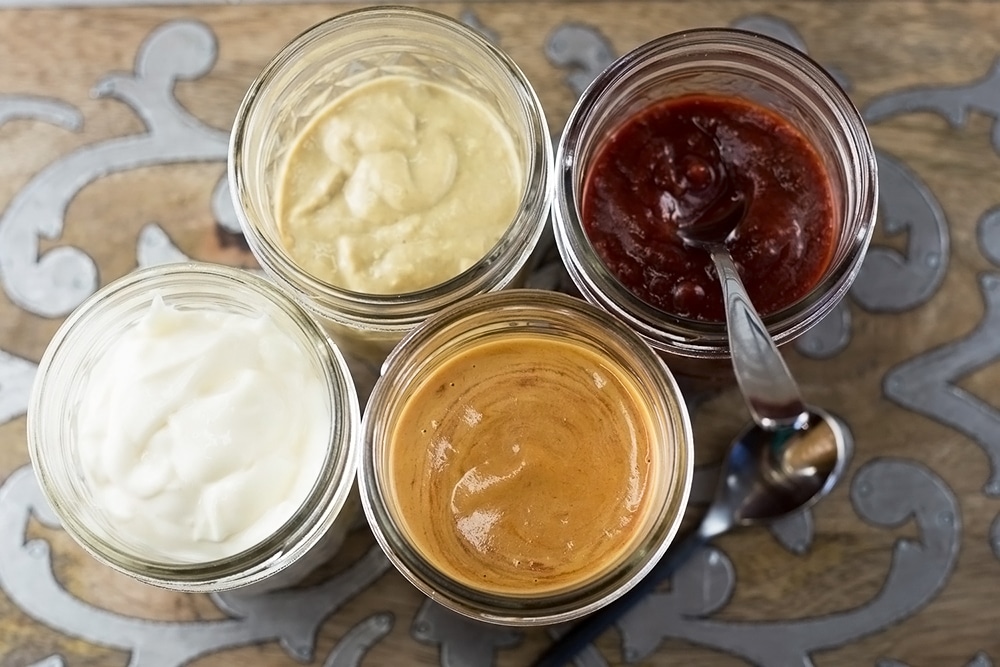 Overhead view of 4 mason jars with different condiments