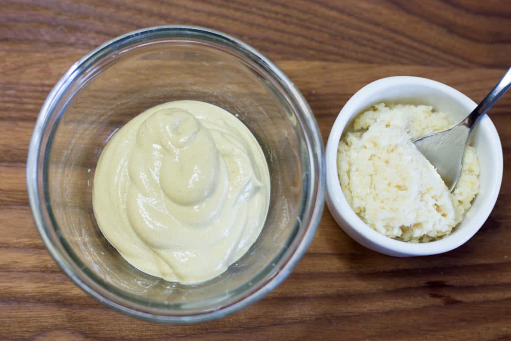Bowl of dijon mustard and bowl of horseradish with spoon