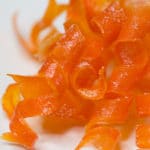 A pile of candied carrot curls on a white plate