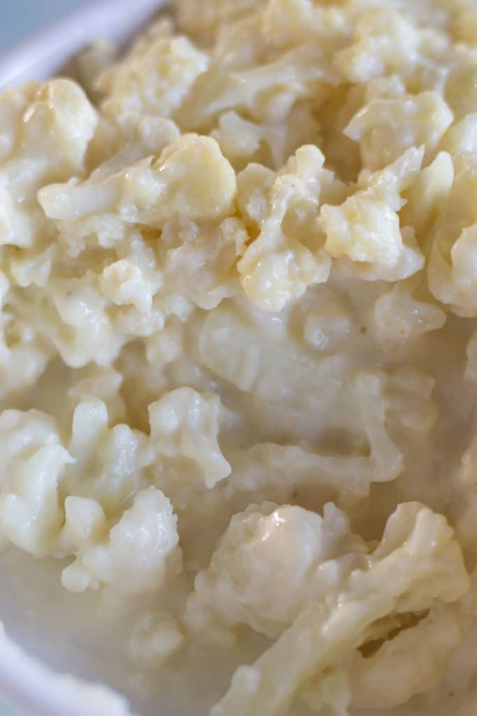 Up close view of baked cauliflower coated with a cream sauce