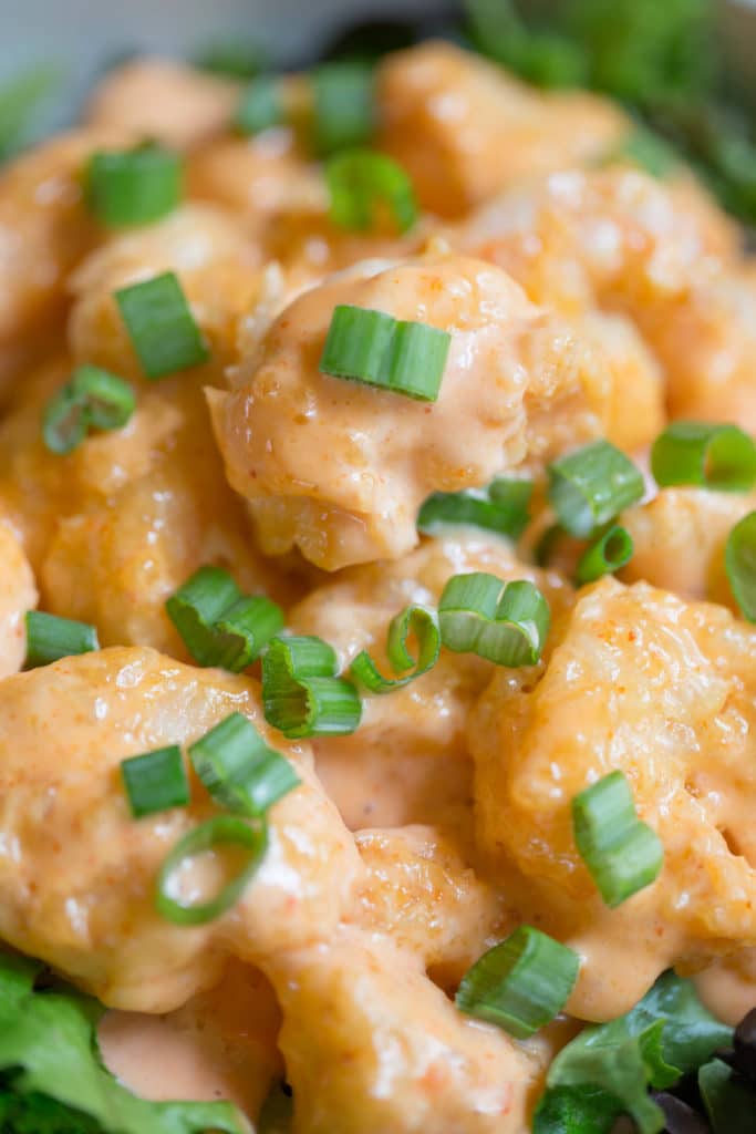 Up close shot of firecracker shrimp garnished with green onions