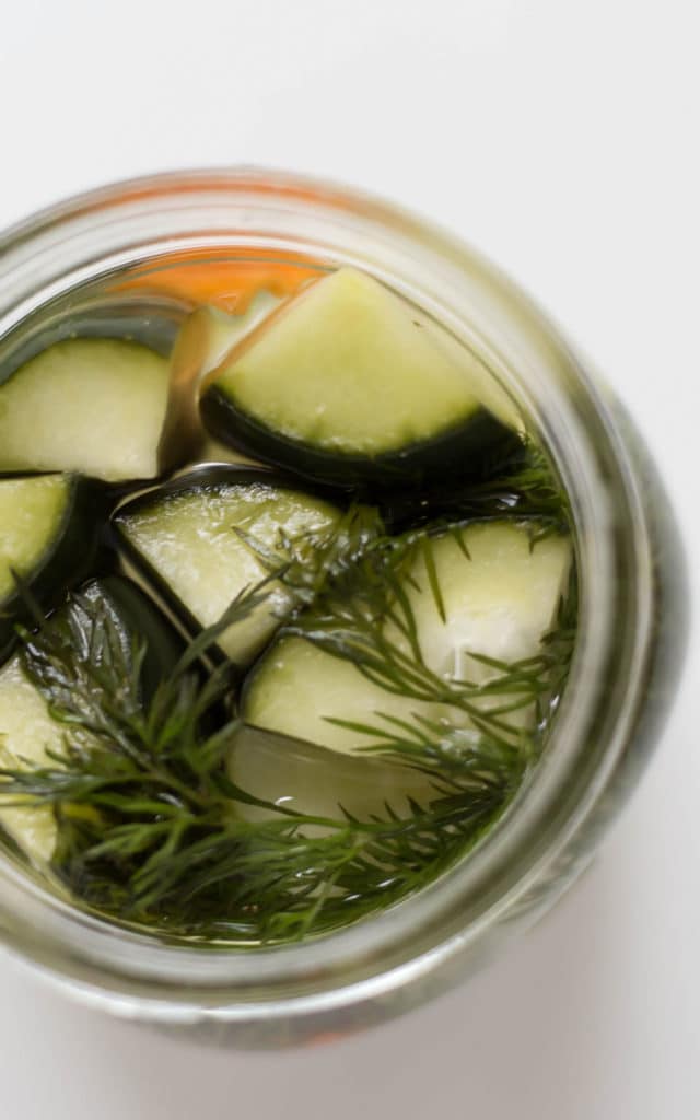 Ann overhead view of an open mason jar with pickle spears and dill