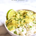 White bowl of Guatemalan stew over white rice with a lime wedge