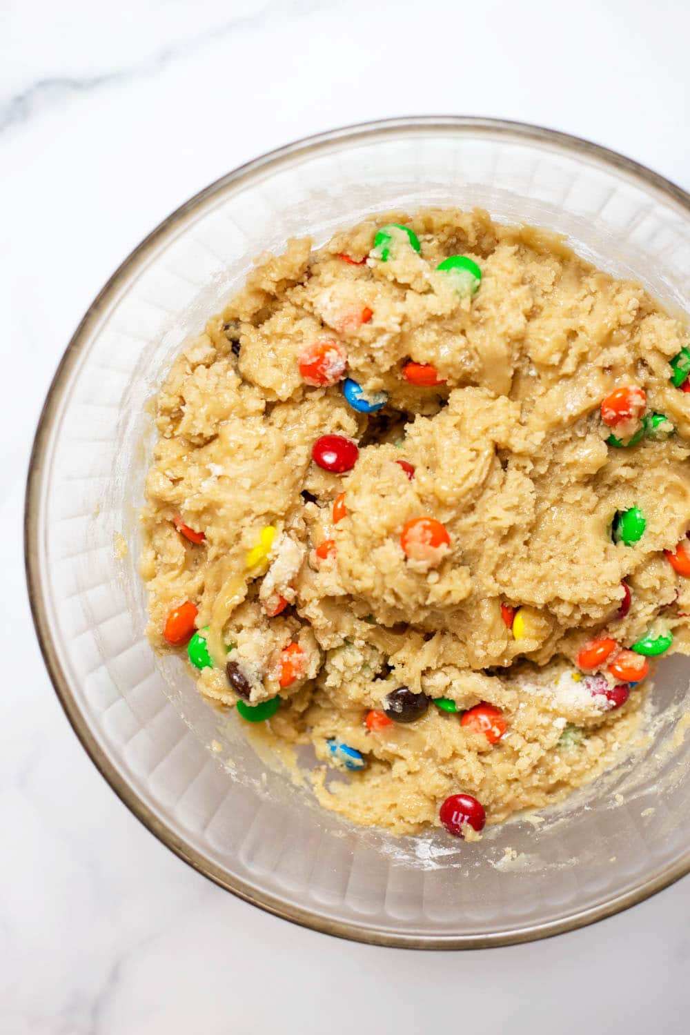 A clear bowl of M&M cookie dough