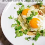 White plate with 2 sunny side up eggs garnished with cilantro and hollandaise sauce