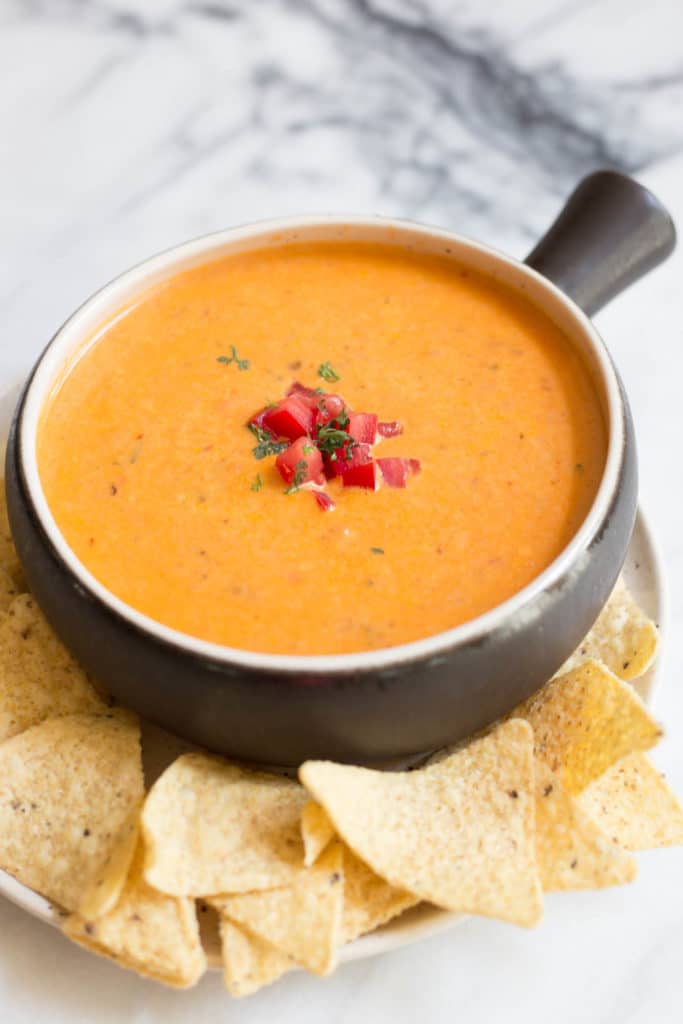Brown crock with spicy queso dip and tortilla chips