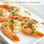 A white plate with cooked skewered shrimp topped with garlic and cilantro