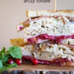 Toasted Turkey Sandwich cut in half and stacked next to cranberries