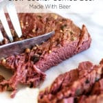 A corned beef brisket being sliced on a marble cutting board