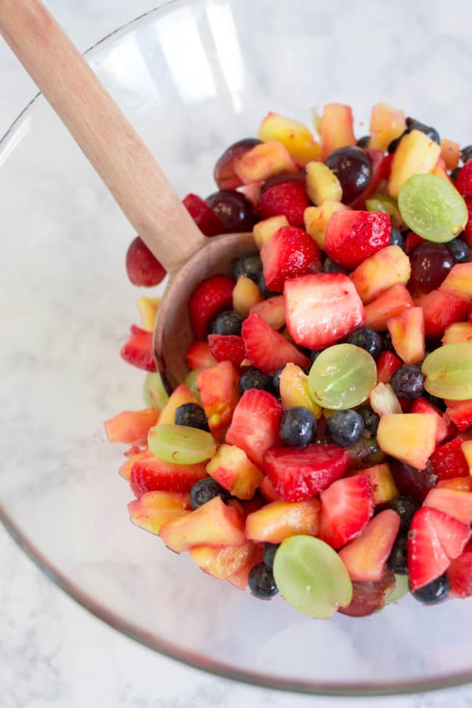An overhead shot of a clear bowl filled with fresh fruit salad