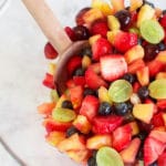 An overhead shot of a clear bowl filled with fresh fruit salad