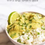White bowl of Guatemalan stew and white rice garnished with cilantro and a lime slice
