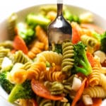 A fork in a bowl of tricolored pasta salad