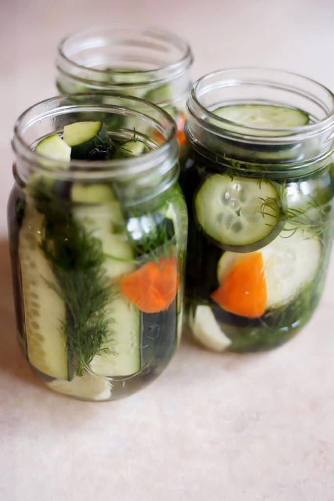 3 mason jars filled with pickles and spices