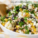 Up close view of corn salad garnished with white crumbled cheese and chopped cilantro