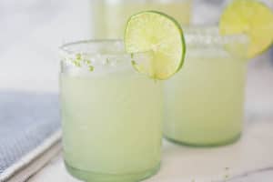 Two glasses of margaritas with a slice of lime on the rim