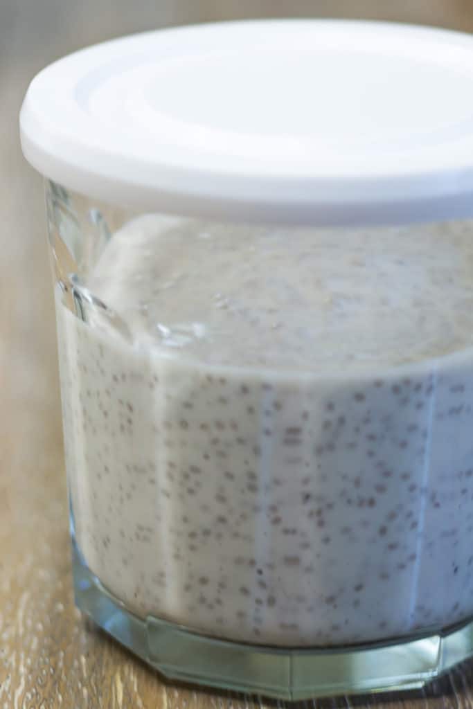 A clear jar with a white lid filled with chia pudding