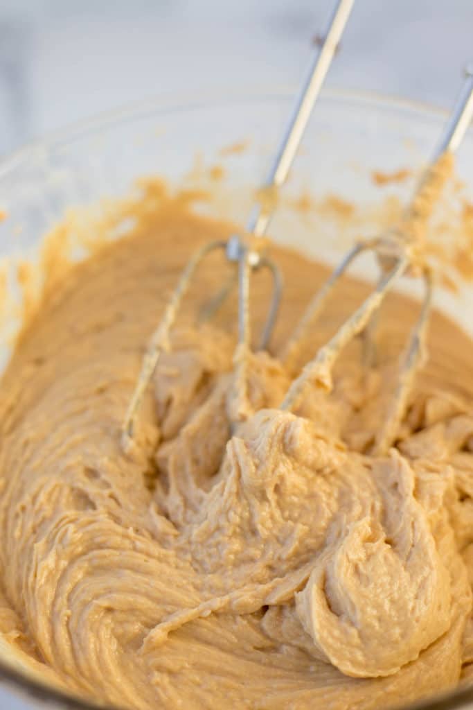 Up close view of beaters in a bowl of peanut butter frosting