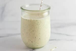 A clear jar of ranch dressing with a silver spoon inside