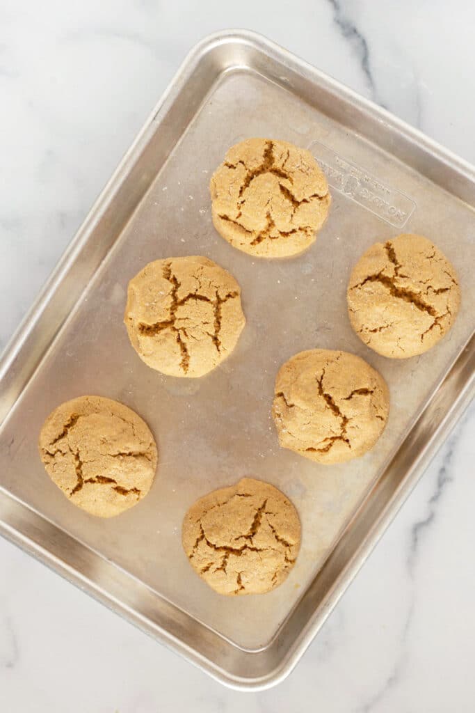 Overhead view of baked peanut butter cookies on a baking sheet