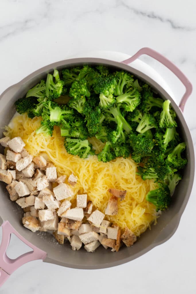 Overhead view of a skillet with diced chicken, spaghetti squash, and broccoli