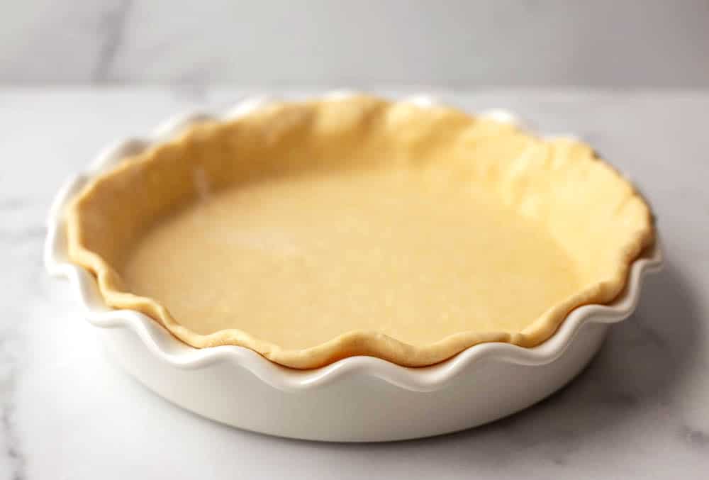 White pie dish with uncooked pie crust